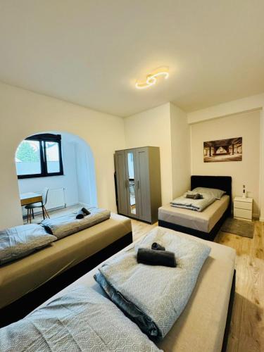 a bedroom with two beds and a table in it at RheinZeit Apartment Köln Bonn in Niederkassel