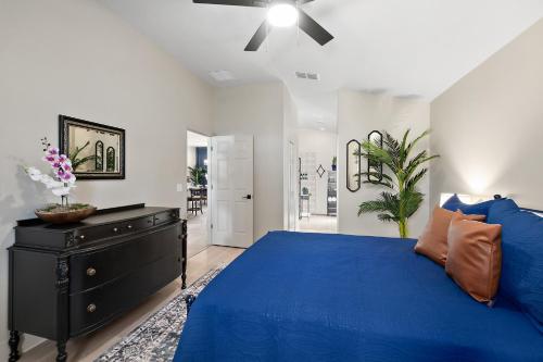 a bedroom with a blue bed and a black dresser at The Palms at Eastwood in Palm Coast