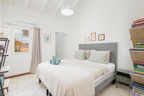 a bedroom with a large white bed with a teddy bear on it at Spanish Water Pier in Jan Thiel
