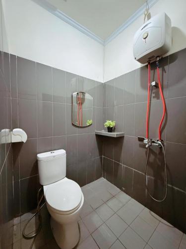 a bathroom with a toilet and a shower at URVANA Hotel By Majestra Hospitality in Kamparganya