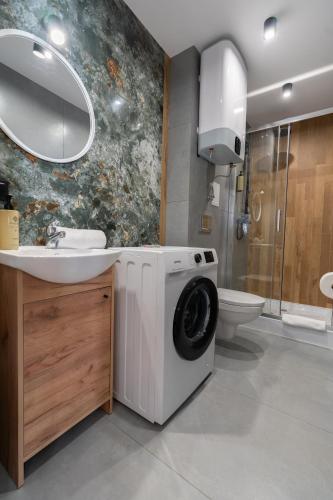 a bathroom with a washing machine and a sink at HostLoop Apartments - Świętego Pawła 10 in Katowice