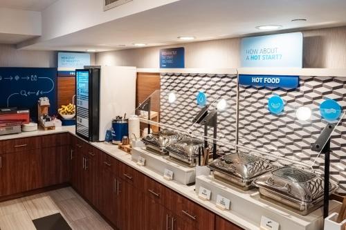 a restaurant with a counter with pots and pans at Holiday Inn Express Maspeth by IHG in Queens
