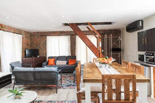 a kitchen and living room with a table and chairs at Be My Guest Lodge in Bloubergstrand