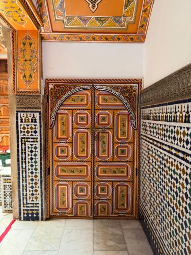 a large wooden door in a room with tiles at Riad Majorelle in Rabat