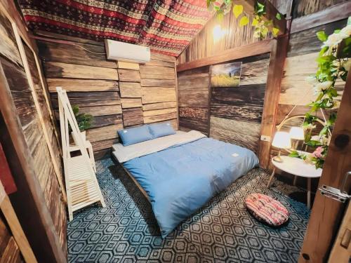 une chambre avec un lit dans une pièce aux murs en bois dans l'établissement Mộc HomeStay Trạm Tâu, à Trạm Tấu