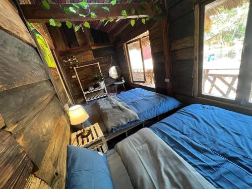 - une chambre avec 2 lits dans une cabane en bois dans l'établissement Mộc HomeStay Trạm Tâu, à Trạm Tấu