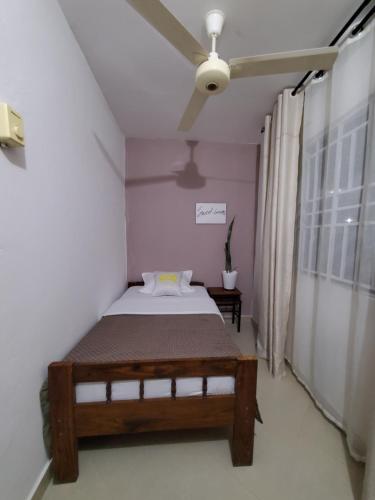 a bedroom with a bed and a ceiling fan at Faraja Homestay Mwanza in Mwanza