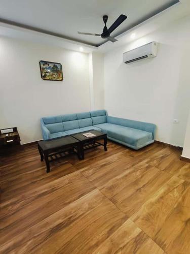 a living room with a blue couch and a table at Ganges Blossom Luxury Stay in Haridwār