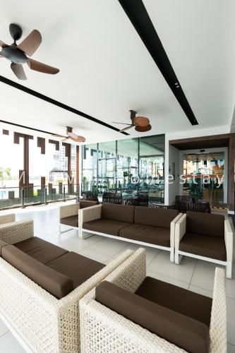 a living room with couches and a ceiling fan at Summer Cozy Studio Room in Perai