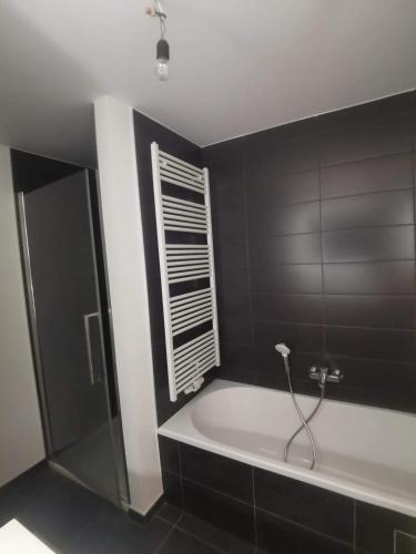 a bathroom with a bath tub and a window at Habitación en metro erasme in Brussels