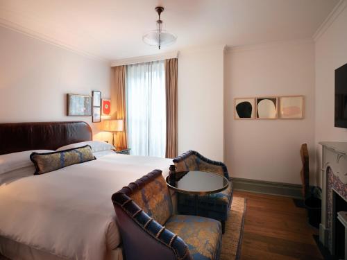 a bedroom with a bed and a table and a chair at NoMad London in London