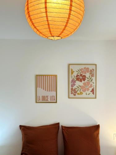 a lamp hanging over a couch with two pictures on the wall at Le Bastion - Fougères in Fougères