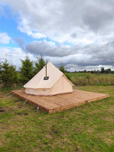 a white tent on a wooden platform in a field at Mardi talu Glamping 
