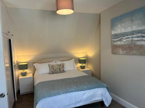 a bedroom with a bed with two night stands and two lamps at Stornoway Townhouse in Stornoway