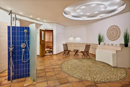 a bathroom with a shower and chairs in a room at Four Points Flex by Sheraton Ratingen Düsseldorf Airport in Ratingen