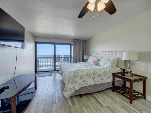 a bedroom with a bed and a ceiling fan at Island House BeachFront Condo Hotel in Corpus Christi