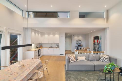 a living room and kitchen with a couch and a table at Seaview and private roof top terrace with jacuzzi in Lofoten in Svolvær