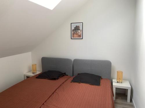a bedroom with a bed with two pillows on it at Les COSY Apparts in Contrexéville