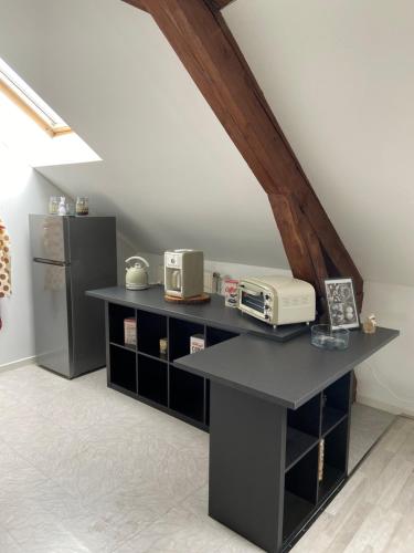 a kitchen with a counter with a microwave and a refrigerator at Les COSY Apparts in Contrexéville