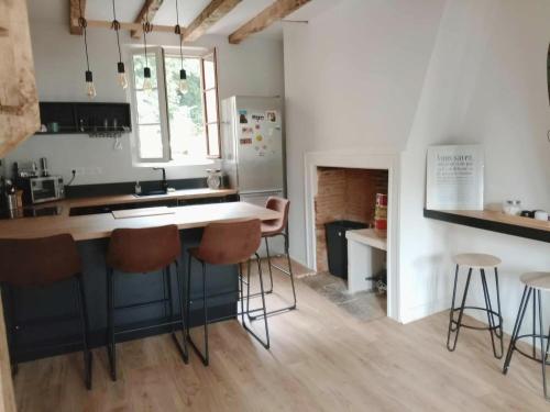 a kitchen with a counter and stools in it at L horizon d Aristide - 1 Chambre in Tulle