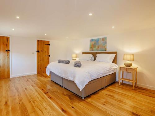 a large bedroom with a large bed and wooden floors at 2 Bed in Kings Nympton 87985 in Kings Nympton