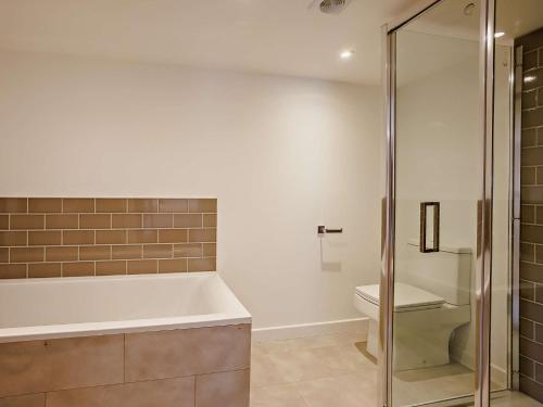 a bathroom with a bath tub and a toilet at 2 Bed in Kings Nympton 87985 in Kings Nympton