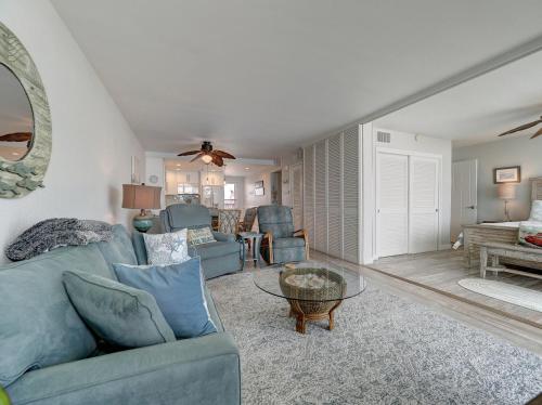 a living room with a blue couch and a table at Island House BeachFront Condo Hotel in Corpus Christi