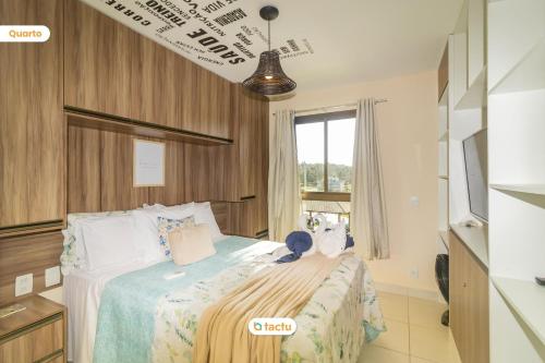 a bedroom with a bed with a teddy bear on it at Estúdio prático e aconchegante no VG Sun in Paracumbuca