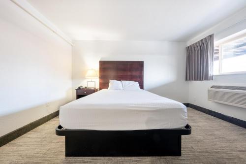 a bedroom with a large white bed in it at Banfield Studios By OYO Portland OR in Portland