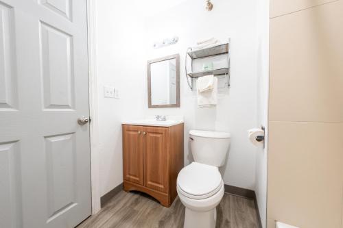 a white bathroom with a toilet and a sink at Banfield Studios By OYO Portland OR in Portland