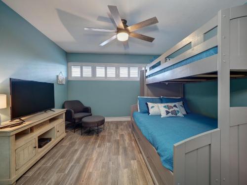 a bedroom with a bunk bed and a ceiling fan at Island House BeachFront Condo Hotel in Corpus Christi