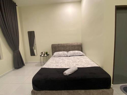 1 dormitorio con 1 cama grande con reposapiés negro en AZ Roomstay Pendang, en Pendang