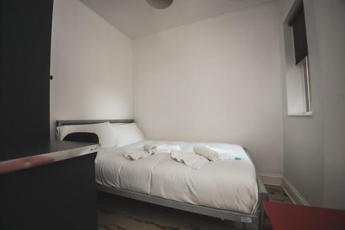 a small bedroom with a bed with towels on it at Modern Stranmillis 4 Bed in Belfast