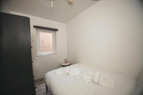 a bedroom with a white bed with bows on it at Modern Stranmillis 4 Bed in Belfast
