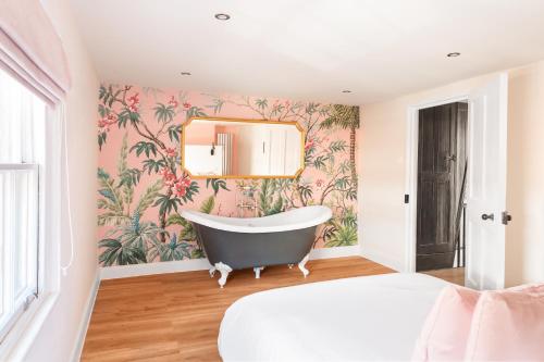 a bathroom with a bathtub and a floral wallpaper at Worthing town house in Worthing