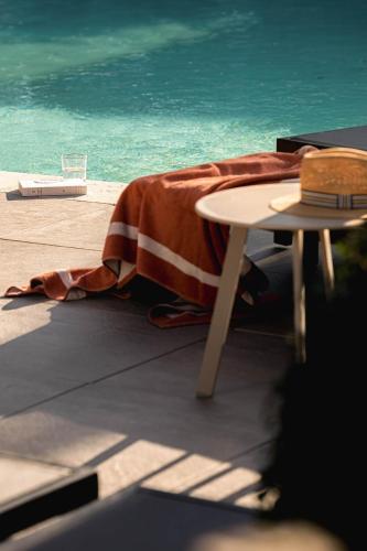 a table with a blanket sitting next to the ocean at Contact Hôtels Le Savigny & Spa in Blacé