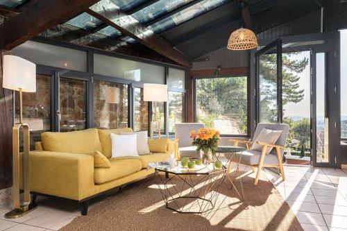 a living room with a yellow couch and a table at Contact Hôtels Le Savigny & Spa in Blacé