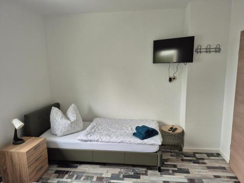 a small bedroom with a bed with a tv on the wall at Ferienhaus Thalia 2 in Übach-Palenberg
