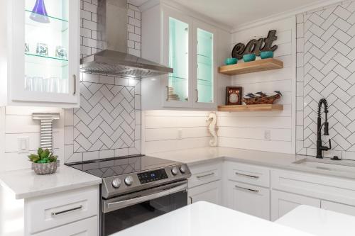a kitchen with white cabinets and a stove top oven at Island House BeachFront Condo Hotel in Corpus Christi