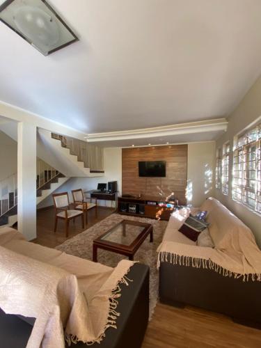 a living room with two beds and a tv at A Casa à Beira do Lago Bortolan in Poços de Caldas