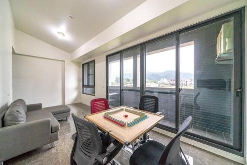 a living room with a table and chairs and a large window at 自在如家獨棟民宿 in Toucheng