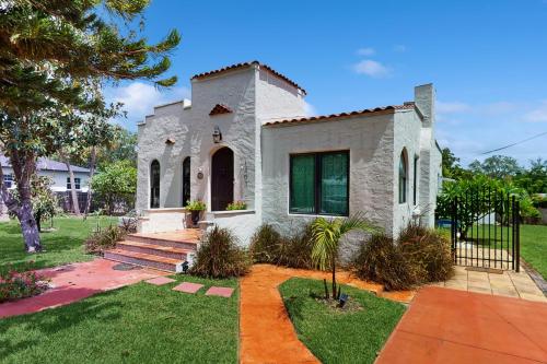 a white house with a gate and a yard at Casa Castillo in Sebring