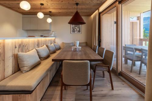 een eetkamerbank met een tafel en stoelen bij Antarès ORION 201 - luxury apartment ski inski out in Méribel
