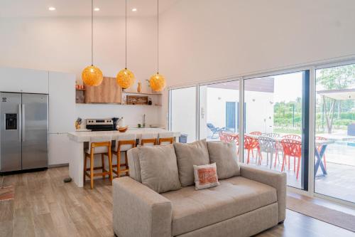 a living room with a couch and a kitchen at Villa Blanca in Esterillos Este