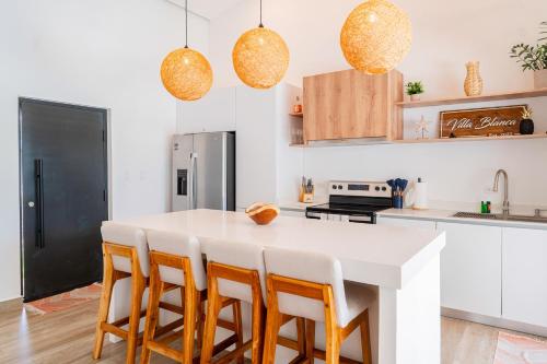 a kitchen with a large white island with bar stools at Villa Blanca in Esterillos Este