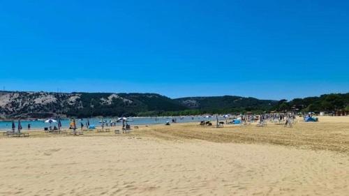 eine Gruppe von Menschen am Strand mit dem Wasser in der Unterkunft Apartment Mira in Supetarska Draga