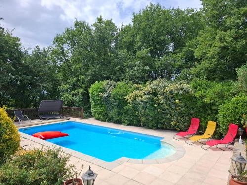 a swimming pool with colorful chairs and a swimming pool at Demeure de charme OLIVIRA in Vesseaux