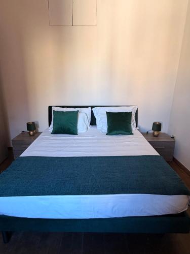 Un dormitorio con una cama grande con dos almohadas verdes. en Casa Mia Trastevere, en Roma