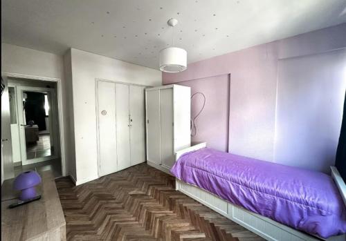 a bedroom with a purple bed in a room at DEPARTAMENTO pleno centro MAR DEL PLATA in Mar del Plata