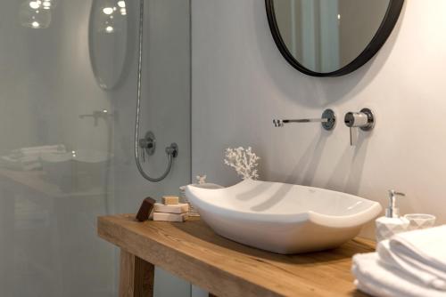 a bathroom with a white bowl sink on a wooden counter at Seven Suites in Glinado Naxos